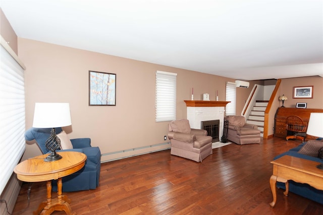 66 Parma Rd, Island Park, NY 11558 - living room with a baseboard radiator, a brick fireplace, a wall mounted AC, and wood finished floors
