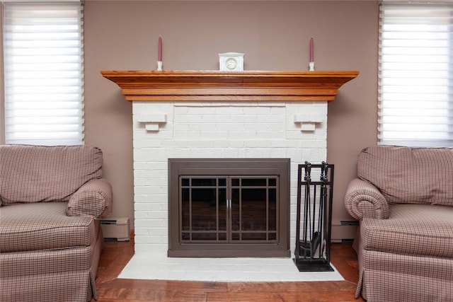 66 Parma Rd, Island Park, NY 11558 - detailed view of baseboard heating, a glass covered fireplace, and wood finished floors