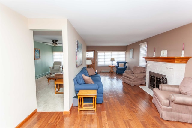 66 Parma Rd, Island Park, NY 11558 - living area with hardwood / wood-style floors, a brick fireplace, a ceiling fan, and baseboard heating
