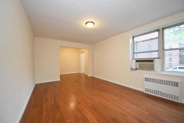 26-21 Union St Unit 1B, Flushing, NY 11354 - spare room featuring radiator heating unit, wood finished floors, and cooling unit