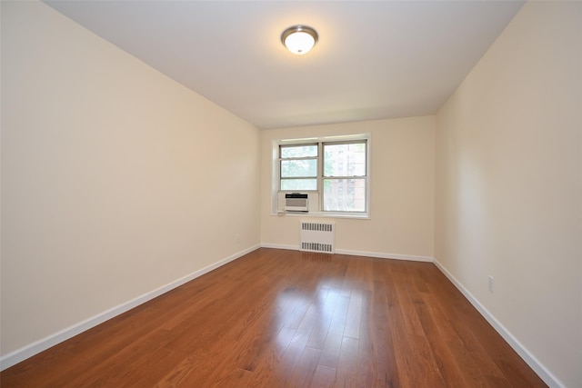 26-21 Union St Unit 1B, Flushing, NY 11354 - empty room featuring radiator heating unit, cooling unit, and dark wood-style floors