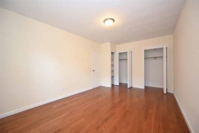26-21 Union St Unit 1B, Flushing, NY 11354 - unfurnished bedroom featuring multiple closets and dark wood-style flooring