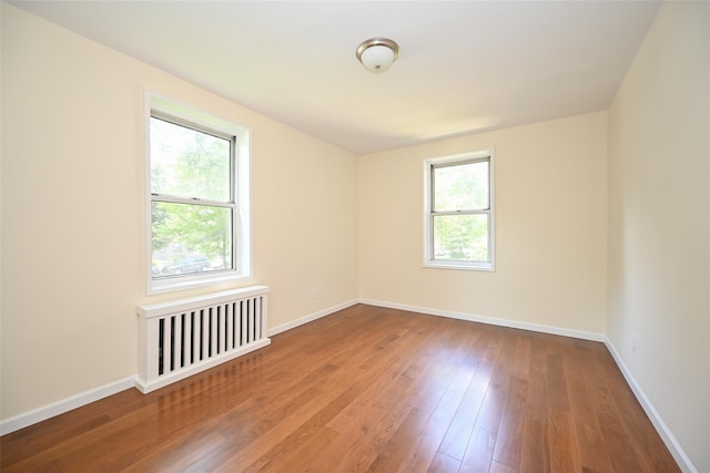 26-21 Union St Unit 1B, Flushing, NY 11354 - unfurnished room with radiator and hardwood / wood-style flooring