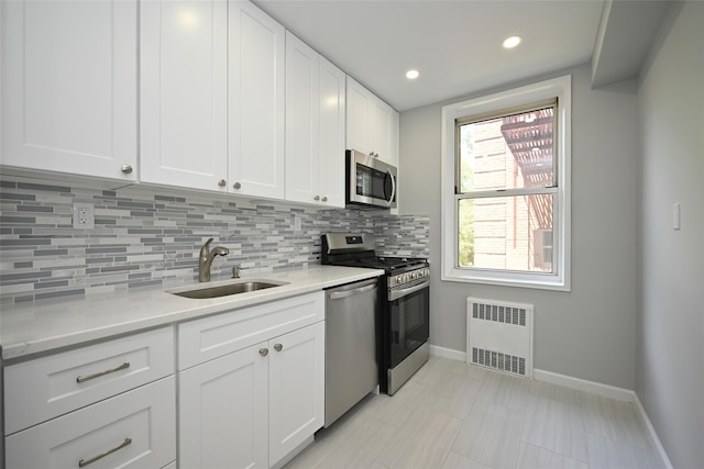 26-21 Union St Unit 1B, Flushing, NY 11354 - kitchen featuring appliances with stainless steel finishes, radiator heating unit, decorative backsplash, light countertops, and white cabinetry