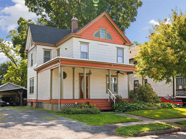 135 Washington Ave, Saugerties, NY 12477 - victorian house with a ceiling fan, covered porch, a chimney, a detached carport, and roof with shingles