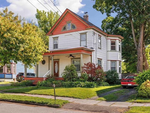 135 Washington Ave, Saugerties, NY 12477 - victorian-style house with a chimney, a ceiling fan, a porch, and a front yard