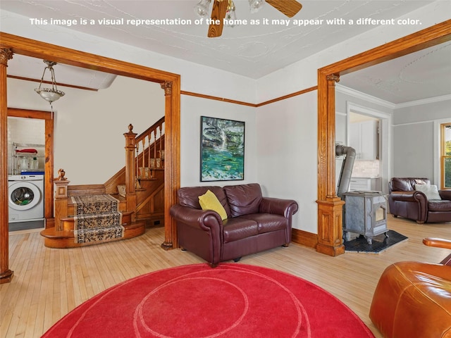 135 Washington Ave, Saugerties, NY 12477 - living room with washer / clothes dryer, hardwood / wood-style flooring, a wood stove, ornamental molding, and stairs