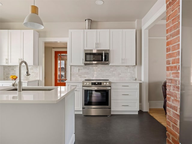 135 Washington Ave, Saugerties, NY 12477 - kitchen featuring appliances with stainless steel finishes, light countertops, tasteful backsplash, and white cabinets