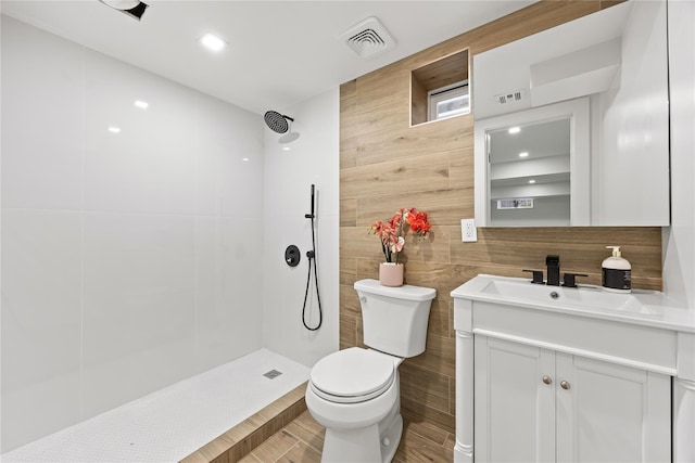 226-07 76th Rd, Bayside, NY 11364 - bathroom featuring tiled shower, vanity, tile walls, and wood finished floors