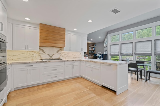 63 Sutton Pl, Manhasset, NY 11030 - kitchen featuring a peninsula, custom exhaust hood, white cabinets, light wood-type flooring, and recessed lighting
