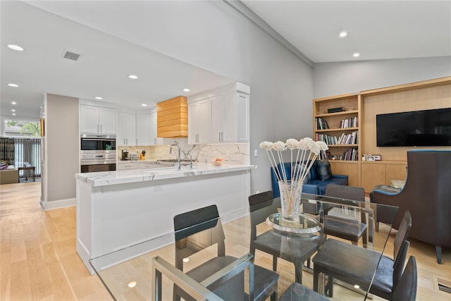 63 Sutton Pl, Manhasset, NY 11030 - dining room with light wood-style flooring, lofted ceiling, and recessed lighting