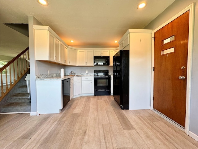23 Chase Ln, Levittown, NY 11756 - kitchen with black appliances, light wood finished floors, white cabinets, and recessed lighting