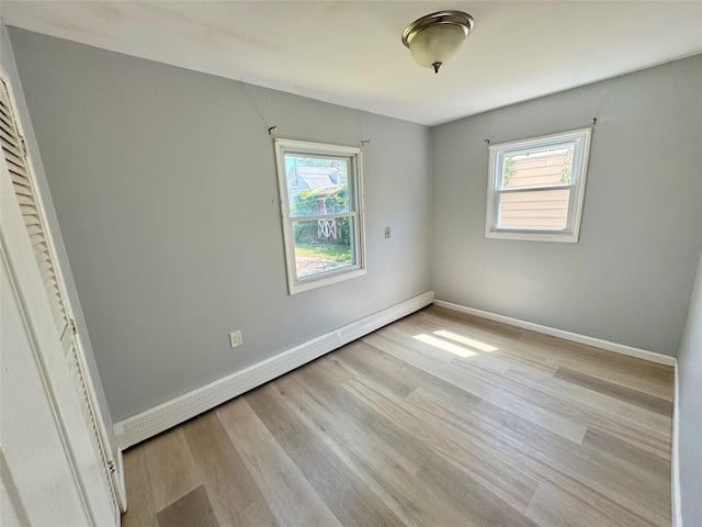 23 Chase Ln, Levittown, NY 11756 - unfurnished bedroom featuring a baseboard radiator and light wood-style flooring