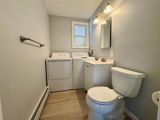 23 Chase Ln, Levittown, NY 11756 - bathroom with separate washer and dryer, wood finished floors, vanity, a baseboard radiator, and a textured ceiling
