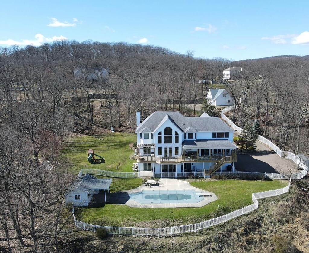 10 Soluri Ln, Tomkins Cove, NY 10986 - rear view of house with a deck, a fenced backyard, stairs, a forest view, and a chimney