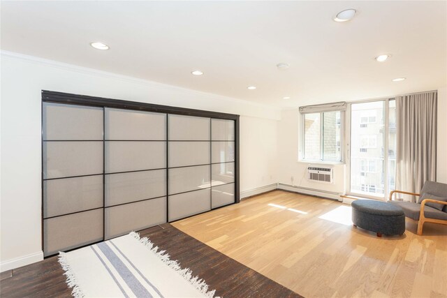 650 Shore Rd Unit 3C, Long Beach, NY 11561 - bedroom with wood finished floors, recessed lighting, a baseboard heating unit, ornamental molding, and a wall unit AC