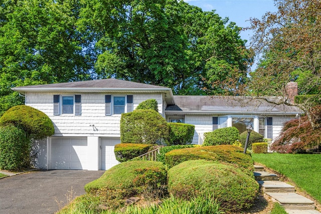 153 Waverly Rd, Scarsdale, NY 10583 - tri-level home featuring a garage, asphalt driveway, and a chimney