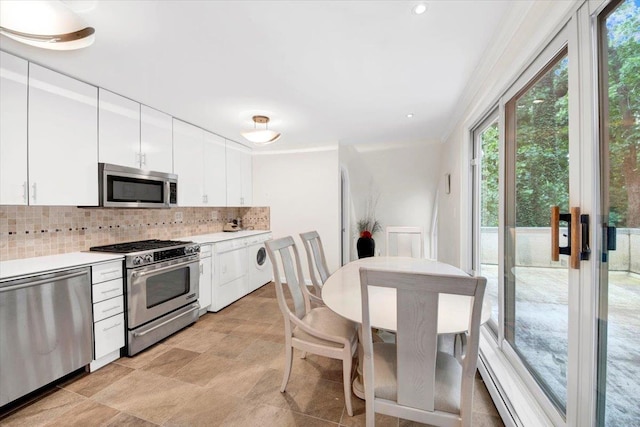 2 Fountain Ln Unit 3P, Scarsdale, NY 10583 - kitchen with stainless steel appliances, plenty of natural light, backsplash, white cabinetry, and ornamental molding