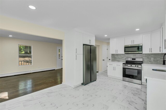 212 Sheldrake Ave, Port Jefferson, NY 11777 - kitchen featuring stainless steel appliances, baseboard heating, white cabinetry, decorative backsplash, and recessed lighting