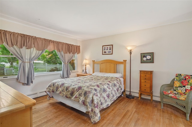 16 Colonial Dr, East Patchogue, NY 11772 - bedroom with baseboard heating, multiple windows, and light wood-style floors