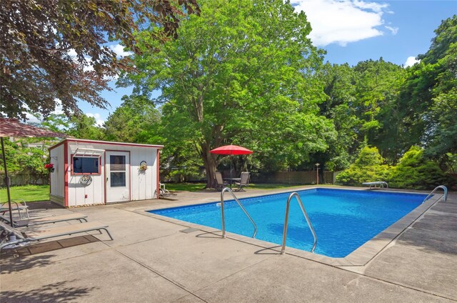 16 Colonial Dr, East Patchogue, NY 11772 - swimming pool with a patio, a storage unit, and a diving board