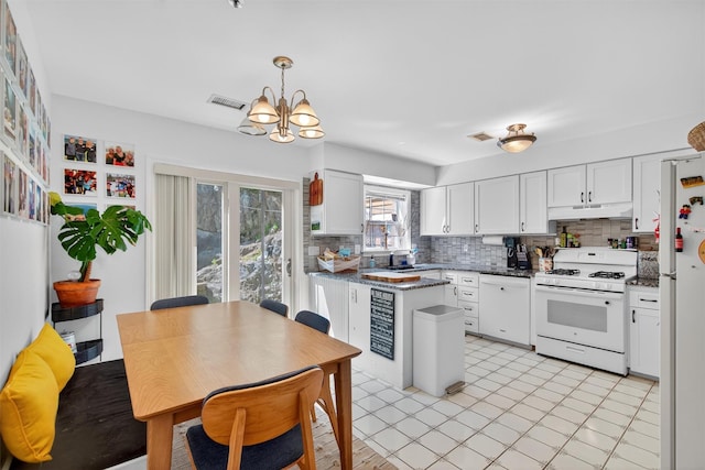 204 Watch Hill Dr, Tarrytown, NY 10591 - kitchen featuring white appliances, under cabinet range hood, decorative backsplash, a chandelier, and white cabinets