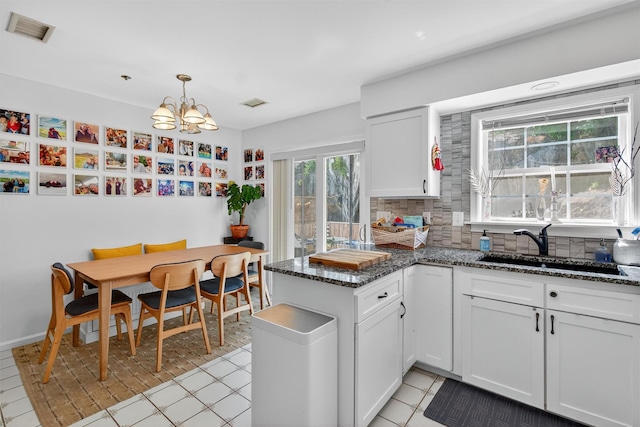 204 Watch Hill Dr, Tarrytown, NY 10591 - kitchen featuring backsplash, a peninsula, a chandelier, and white cabinets