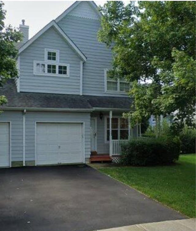11 Northwood Blvd, Central Islip, NY 11722 - view of front facade with covered porch, an attached garage, driveway, and a chimney
