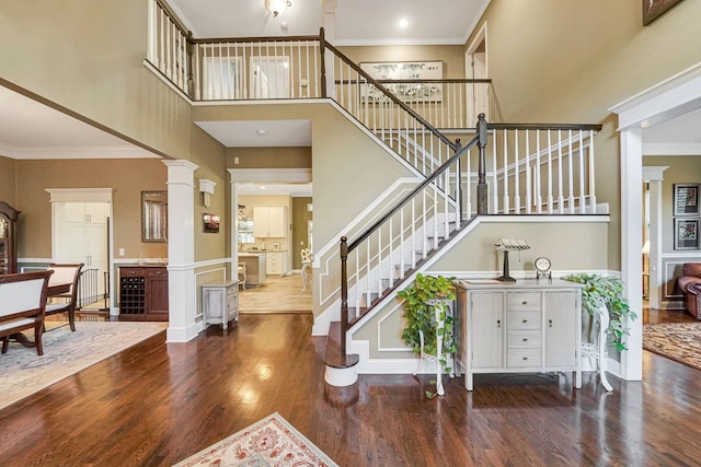 40 Independence Way, Miller Place, NY 11764 - entrance foyer with a high ceiling, wood finished floors, stairway, decorative columns, and crown molding
