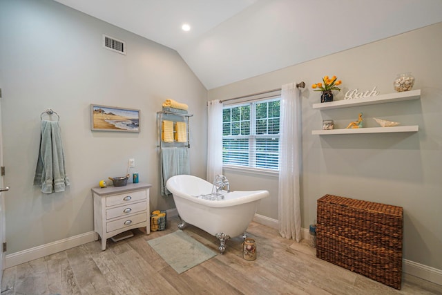 40 Independence Way, Miller Place, NY 11764 - bathroom featuring lofted ceiling, a freestanding tub, wood finished floors, and recessed lighting