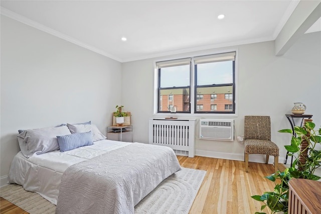 86-29 155th Ave Unit 5N, Howard Beach, NY 11414 - bedroom with radiator heating unit, a wall unit AC, light wood-style flooring, recessed lighting, and crown molding