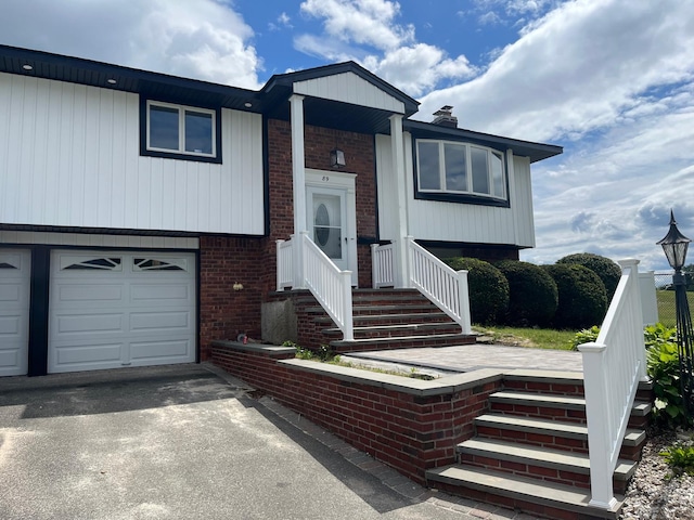 89 Harvest Ln, Commack, NY 11725 - view of front of property featuring brick siding, asphalt driveway, an attached garage, and a chimney