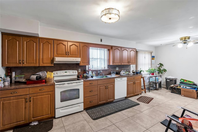 1541 Herzel Blvd, West Babylon, NY 11704 - kitchen featuring white appliances, under cabinet range hood, decorative backsplash, and brown cabinetry