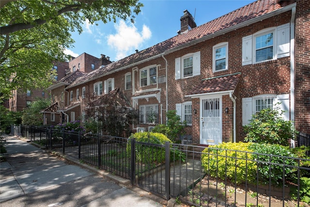 34-42 88th St, Jackson Heights, NY 11372 - townhome / multi-family property with brick siding, a fenced front yard, a chimney, and a residential view