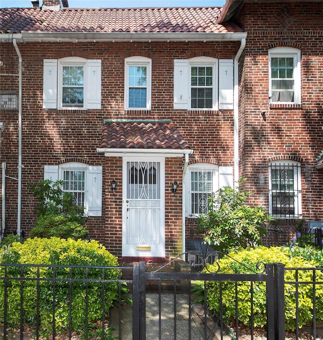 34-42 88th St, Jackson Heights, NY 11372 - view of front of home with a tiled roof, a fenced front yard, and brick siding