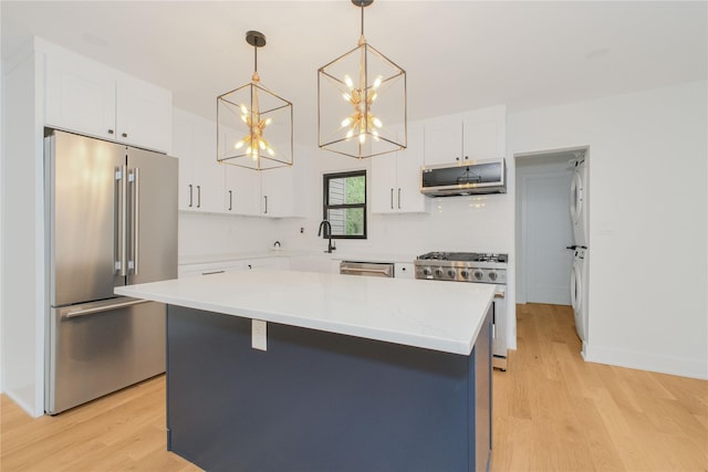 231 Macdougal St, Brooklyn, NY 11233 - kitchen featuring high quality appliances, a chandelier, light wood-type flooring, white cabinetry, and pendant lighting