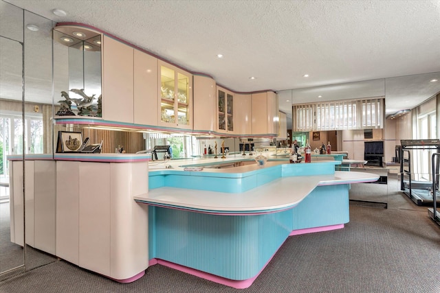 895 Cherry Ln, North Woodmere, NY 11581 - kitchen featuring carpet floors, a textured ceiling, glass insert cabinets, and recessed lighting