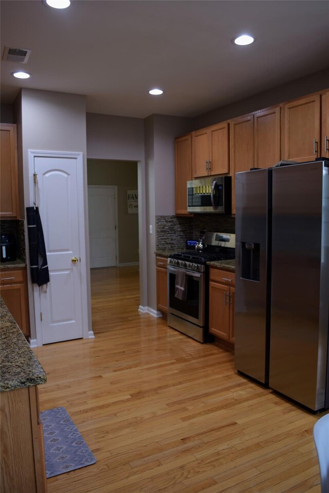 15 Cobblestone Ln, Middletown, NY 10940 - kitchen featuring appliances with stainless steel finishes, backsplash, light wood-type flooring, dark stone counters, and recessed lighting