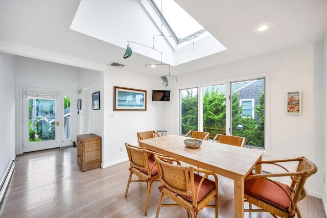 15 Bayside Ave, East Quogue, NY 11942 - dining room featuring a skylight, light wood-type flooring, baseboard heating, and recessed lighting