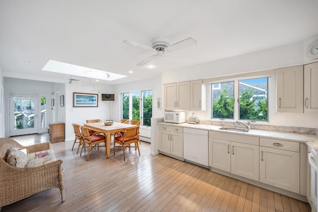15 Bayside Ave, East Quogue, NY 11942 - kitchen featuring white appliances, a skylight, healthy amount of natural light, light countertops, and recessed lighting