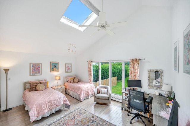 15 Bayside Ave, East Quogue, NY 11942 - bedroom featuring high vaulted ceiling, wood-type flooring, a desk, a skylight, and a baseboard radiator