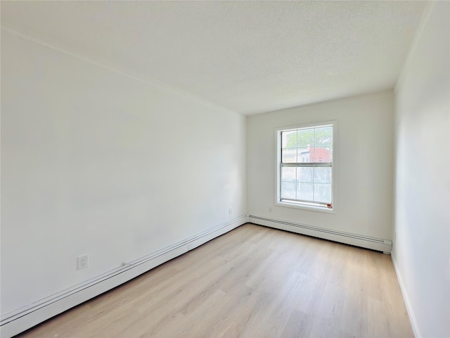 2109 Seward Ave, Bronx, NY 10473 - unfurnished room featuring a baseboard heating unit and light wood-style flooring