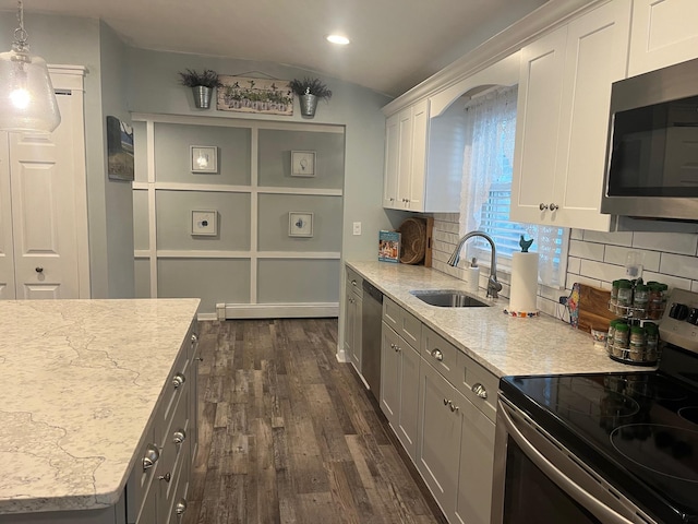 9 Songsparrow Ln, Centereach, NY 11720 - kitchen with stainless steel appliances, tasteful backsplash, dark wood-style flooring, vaulted ceiling, and light stone counters