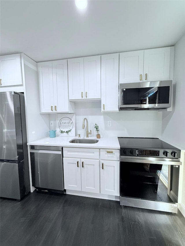 308 Hancock St, Brentwood, NY 11717 - kitchen with appliances with stainless steel finishes, dark wood-type flooring, white cabinetry, and light countertops