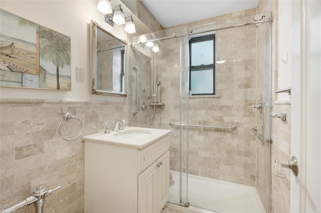 302 96th St Unit 5A, Brooklyn, NY 11209 - bathroom featuring a tile shower, vanity, tile walls, and a wainscoted wall
