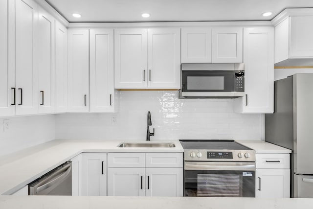 50 Appletree Dr, Saugerties, NY 12477 - kitchen with appliances with stainless steel finishes, white cabinets, light countertops, backsplash, and recessed lighting