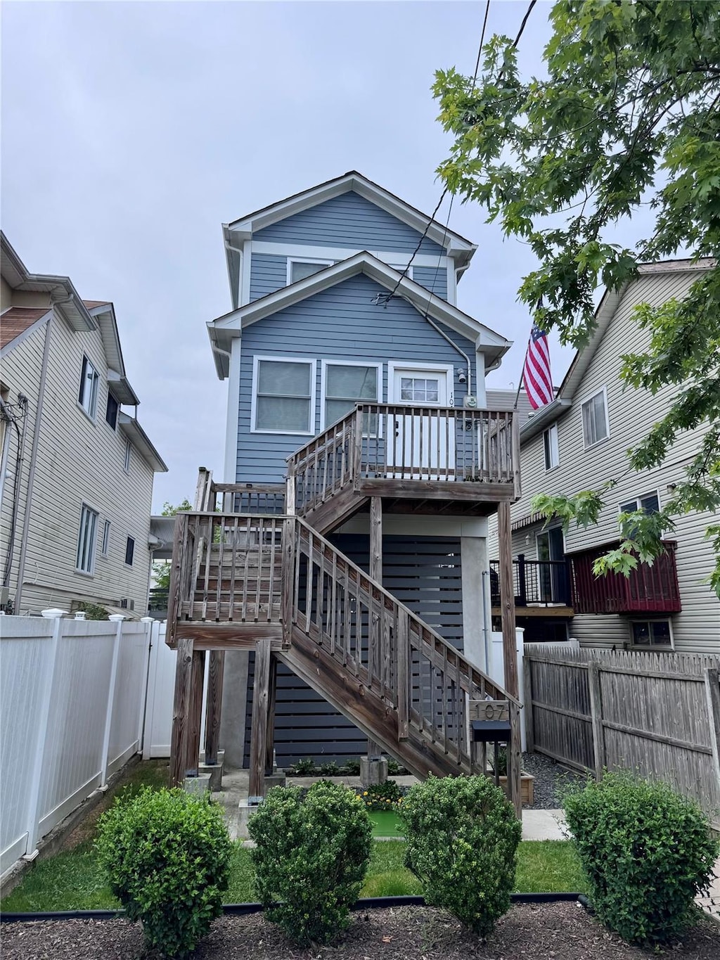 107 Baden Pl, Staten Island, NY 10306 - rear view of property with a fenced backyard, stairs, and a deck