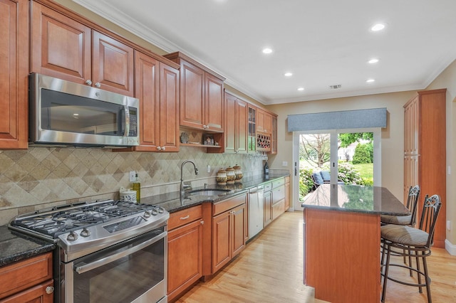 28 Hamlet Dr, Commack, NY 11725 - kitchen with stainless steel appliances, ornamental molding, a breakfast bar area, recessed lighting, and light wood-style flooring