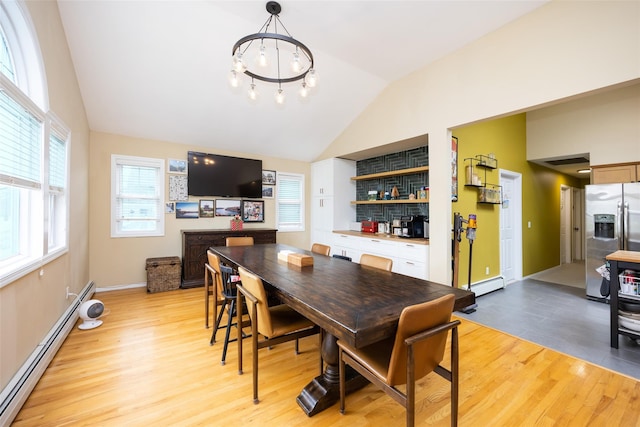 1200 Roger Rd, North Bellmore, NY 11710 - dining area featuring baseboard heating, light wood-style flooring, vaulted ceiling, and healthy amount of natural light