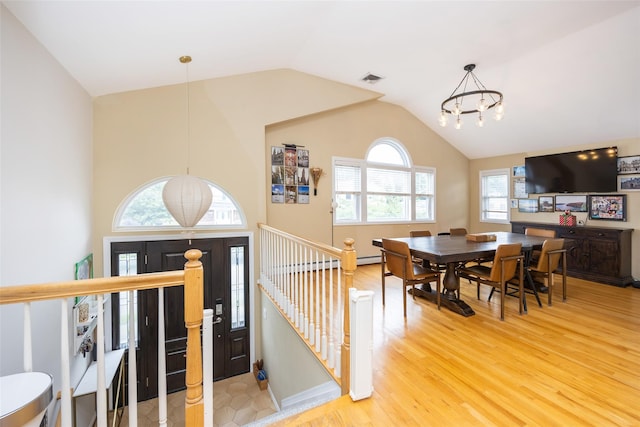 1200 Roger Rd, North Bellmore, NY 11710 - dining room with a chandelier, vaulted ceiling, and wood finished floors